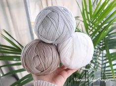 three skeins of yarn sitting on top of each other in front of a palm tree