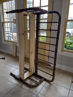 a large wooden object sitting on top of a tile floor next to two big windows