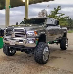 a large gray truck parked in front of a gas station