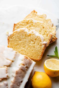 slices of lemon pound cake with icing on a plate next to sliced lemons