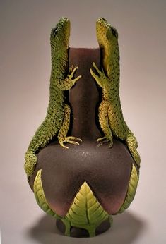 two lizards sitting on top of a vase