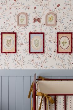 a baby crib in front of a wall with pictures on it