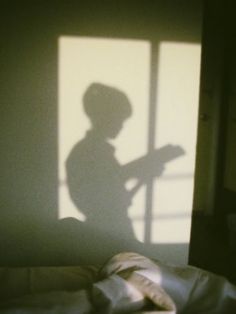 a shadow of a child holding a book