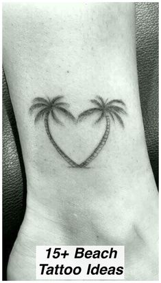 a heart shaped tattoo with two palm trees on the side of the foot, and an inscription