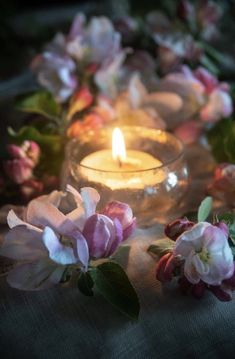 some flowers and a lit candle on a table