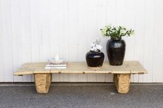 two vases sitting on top of a wooden table next to each other near a white wall