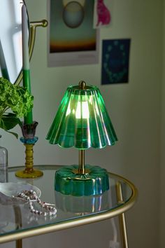 a green lamp sitting on top of a glass table