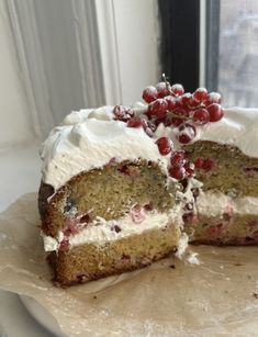 there is a cake with white frosting and berries on it