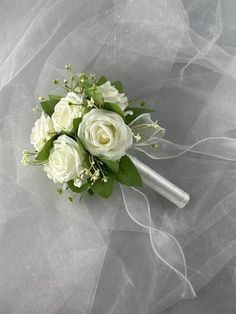 a bridal bouquet with white roses and greenery on a gray background for a wedding