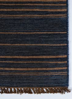 a blue and brown striped rug with fringes