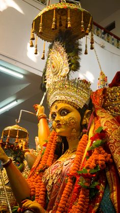 an elaborately decorated statue in front of a chandelier hanging from the ceiling