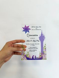 a person holding up a purple and white card