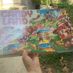 a person holding up a candy land board game in their hand, with the title'candy land'written on it