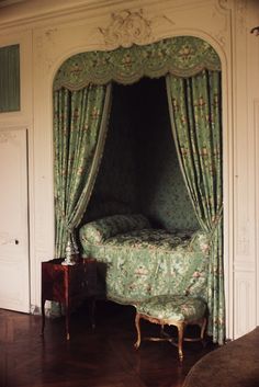 a bed sitting in the middle of a bedroom next to a doorway with curtains on it