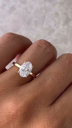 a woman's hand with a diamond ring on top of her finger and an engagement band