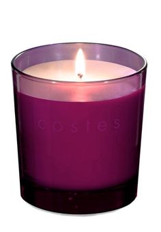 a close up of a candle in a glass container with the word costes printed on it