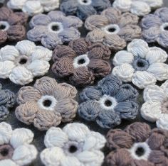 there are many crocheted flowers on the table