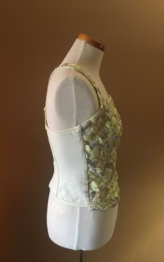 "Beautiful and unusual camisole accented with metallic floral appliqués. The top is made of nylon and Lycra for a slimming effect. Staves are added for a mild support and to maintain a slimming look. Top can be worn with jeans as well as slacks or skirt. Measures 16\" from armpit to armpit 10.5\" from armpit to hem 13\" across the waist This top has a lot of stretch!" Party Fitted Camisole With Tank Straps, Spring Evening Corset With Built-in Bra, Party Top With Boned Bodice And Tank Straps, Spring Evening Tank Top With Built-in Bra, Fitted Lace Tank Top With Tank Straps, Party Tank Top With Spaghetti Straps And Boned Bodice, Party Tank Top With Boned Bodice And Spaghetti Straps, Summer Boned Bodice Tank Top For Night Out, Summer Tank Top With Boned Bodice For Night Out