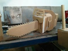 an open cardboard box with a large object in it's mouth sitting on a workbench