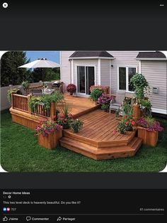 a wooden deck surrounded by potted plants on top of grass next to a house