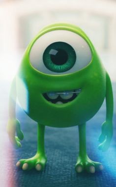 a green monster with big eyes standing on the ground