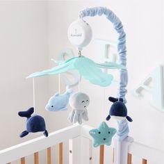 a baby crib with stuffed animals hanging from it