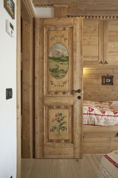 a bedroom with wood paneling and paintings on the door