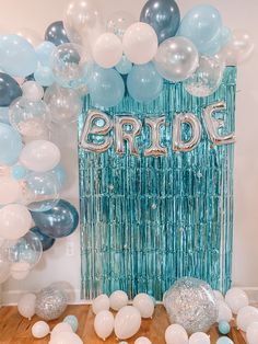 balloons and streamers in front of a backdrop for a bridal party with the word bride on it