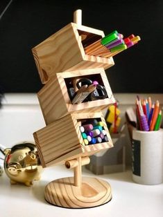 a wooden desk organizer with pencils, markers and pens in it on top of a white table