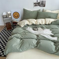 an unmade bed with green sheets and pillows