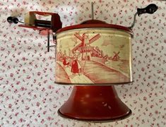 an old fashioned red and white lamp with a windmill on it