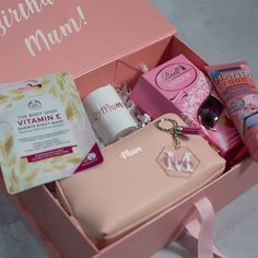 the contents of a woman's personal care kit in a pink gift box,