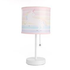 a white table lamp with a pink unicorn print shade