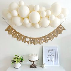 a white cake sitting on top of a table next to a sign that says just married