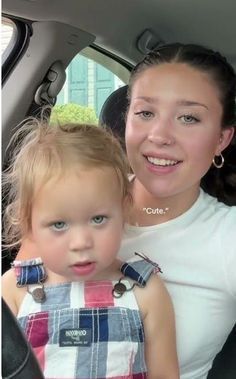 a woman and child sitting in the back seat of a car