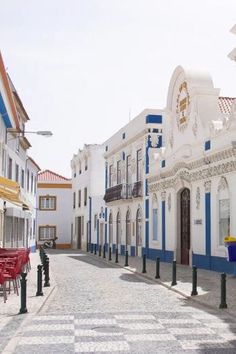 an empty street lined with white and blue buildings