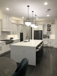 a kitchen with white cabinets and black chairs