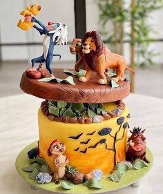 the lion king cake is decorated with figurines