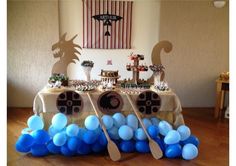 a table topped with blue and white balloons