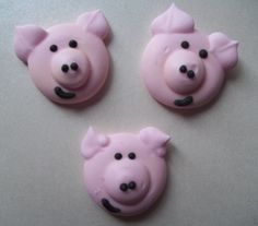 three pink pigs with black eyes and ears