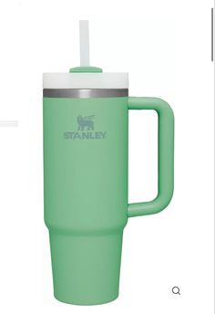 the green travel mug has a straw in it