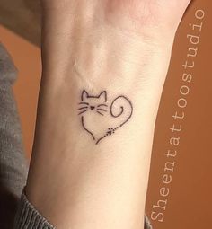 a small cat tattoo on the wrist