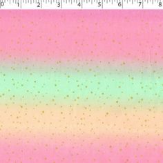 a ruler is next to a pink and green background with small gold dots on it