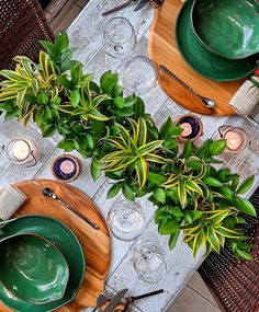 the table is set with green dishes and place settings