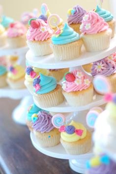 cupcakes are stacked on top of each other with colorful frosting and decorations