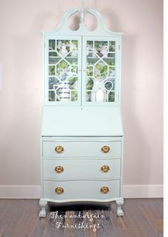 a white dresser with glass doors and drawers