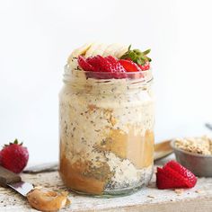 a jar filled with oatmeal and strawberries on top of a table