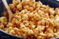 a bowl filled with macaroni and cheese next to a wooden spoon