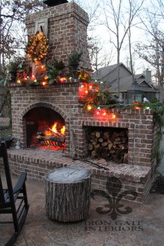 an outdoor fireplace is decorated with pumpkins and greenery for the holiday season,