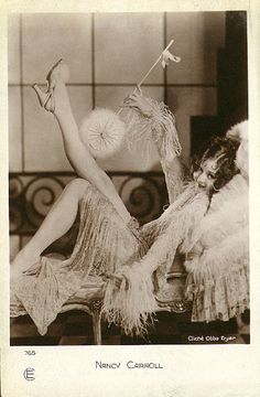 an old black and white photo of a woman in angel costume sitting on a bed